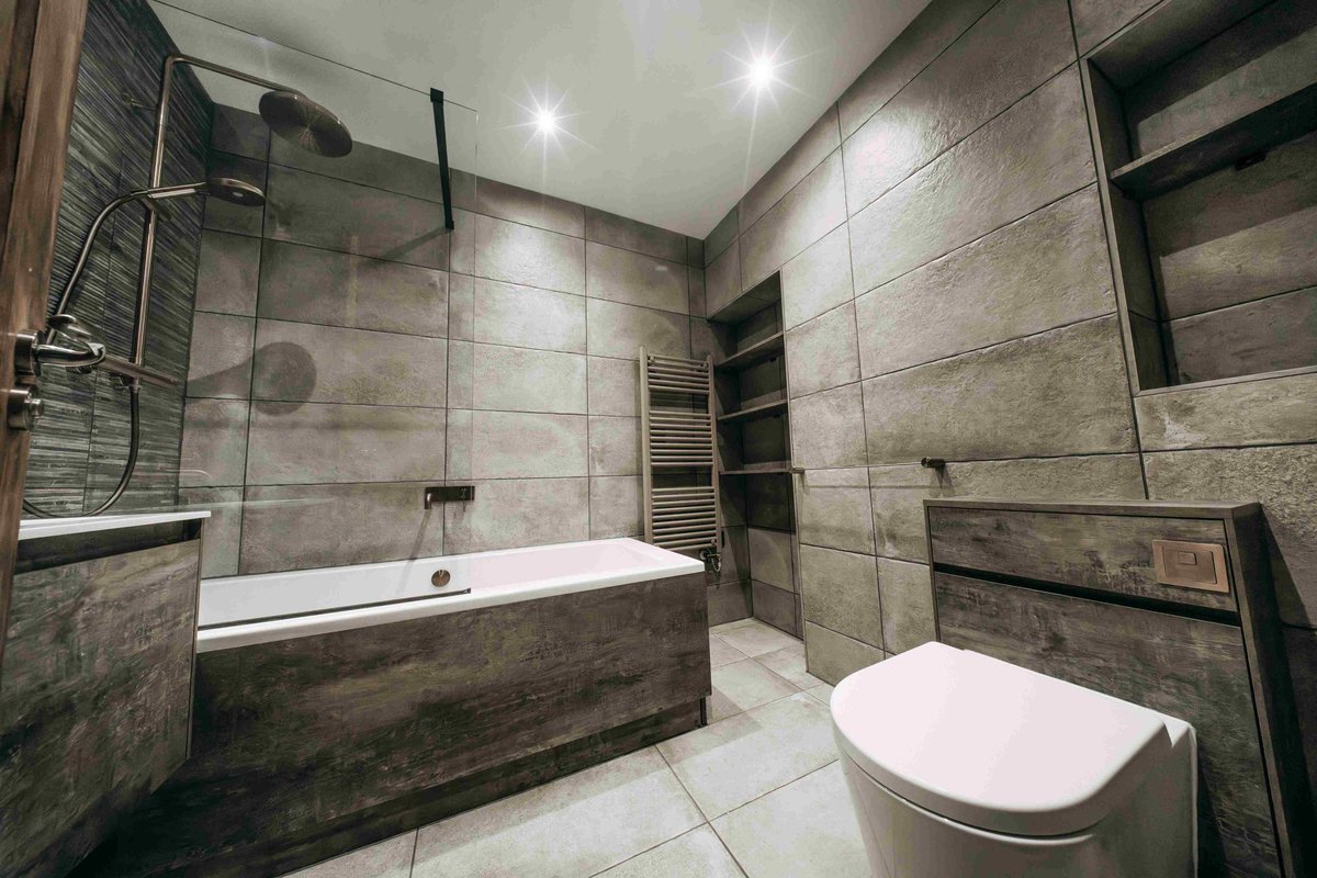 Industrial luxury bathroom in concrete-effect tile and brushed bronze, Cheltenham