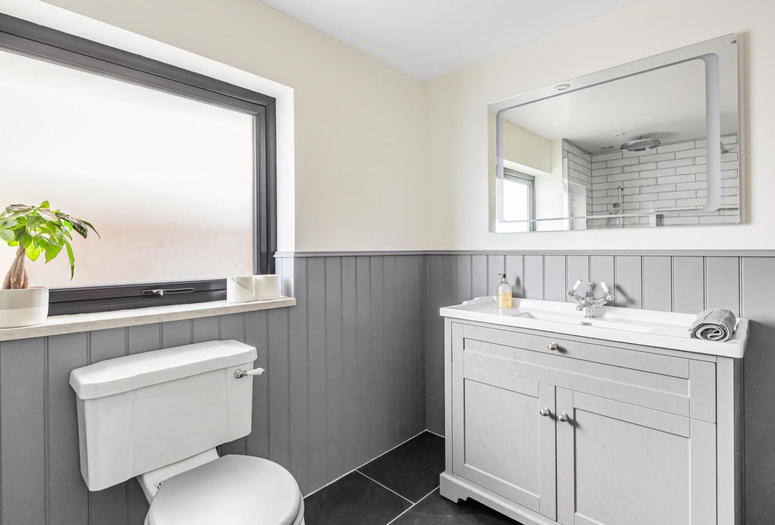 Soft grey family bathroom overview with shaker vanity and panelling