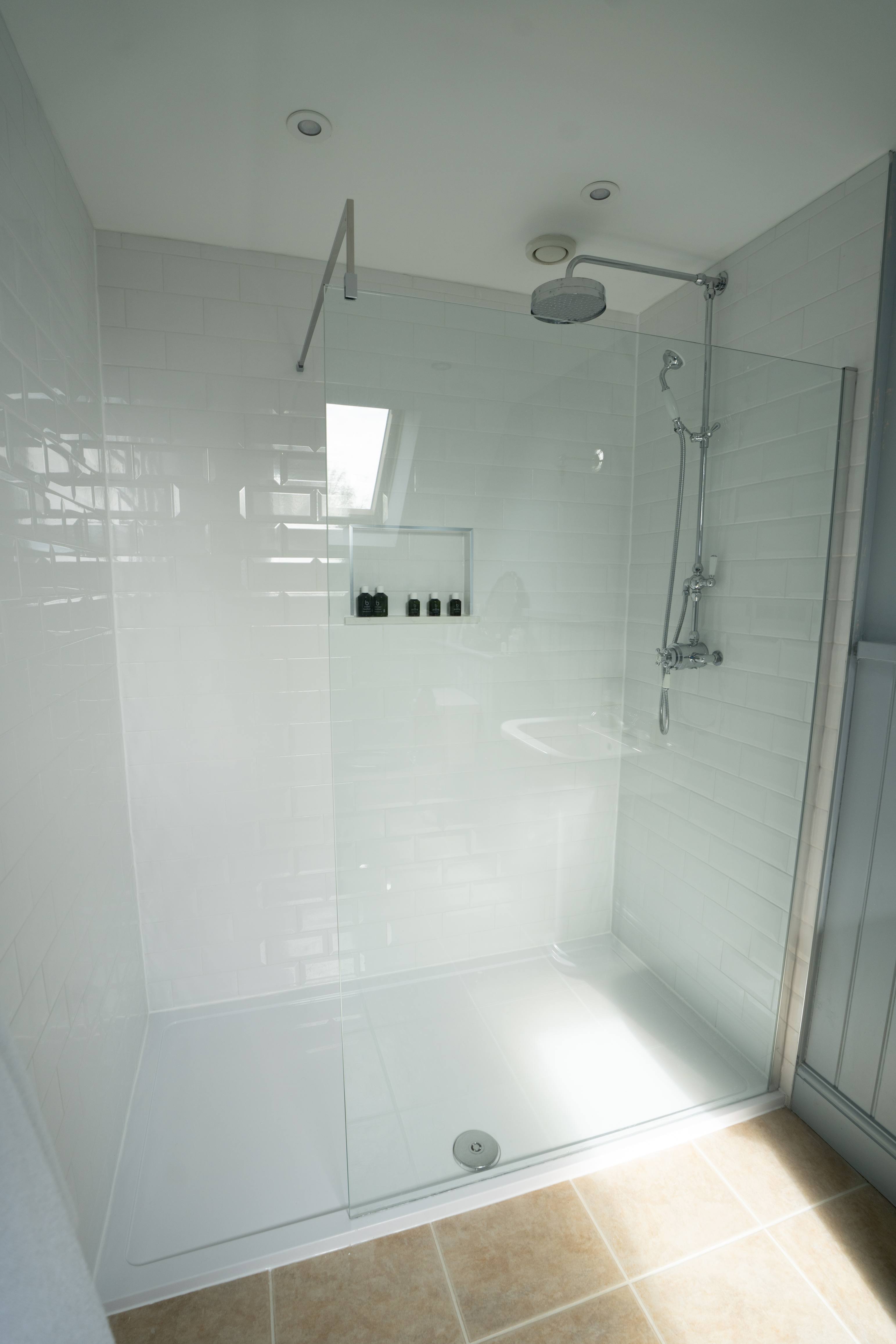Full-width walk-in shower in white metro tile